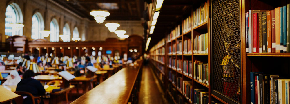 Foto de una antigua biblioteca donde la gente está investigando sobre formación en negociación.